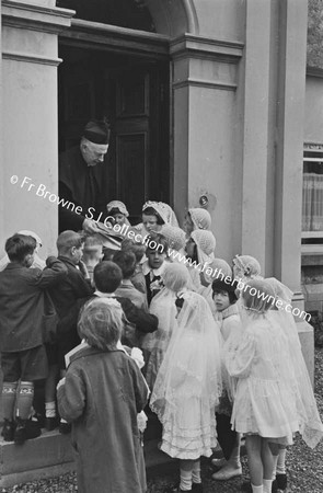 PARISH SCENE  GROUP OF CHILDREN WITH PRIEST ON DOORSTEP OF HOUSE